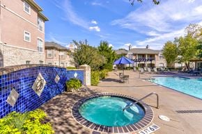 Plano apartment for rent - A blue tiled wall surrounds a hot tub in a backyard.