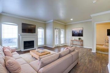 Plano apartment for rent - A living room with a couch, coffee table, and television.