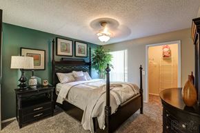 Dallas apartment for rent - A bedroom with a bed, nightstand, and lamp.