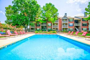 Tulsa apartment for rent - Outdoor swimming pool with lounge chairs and lush landscaping at Greenbriar Apartments, Tulsa, Oklahoma