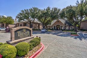 Dallas apartment for rent - A sign that says Trinity Square is in front of a building.