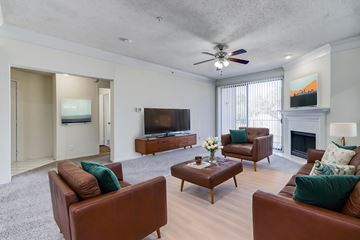 Plano apartment for rent - A living room with brown leather couches and a fireplace.