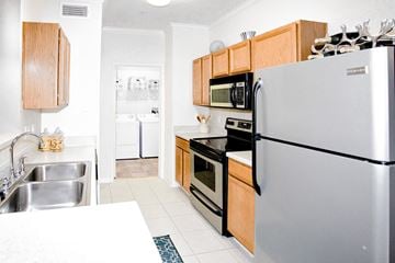 Tulsa apartment for rent - A modern kitchen with a stainless steel refrigerator, microwave, and oven.