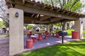Tucson apartment for rent - A covered picnic area with red benches and a mailbox.