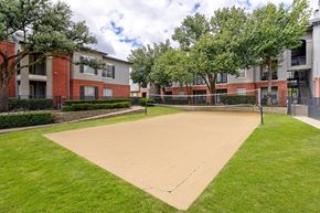 Dallas apartment for rent - A playground with a sandy area and a green lawn.