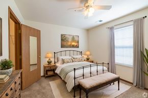 Lawrence apartment for rent - A bedroom with a bed, nightstands, and a ceiling fan.