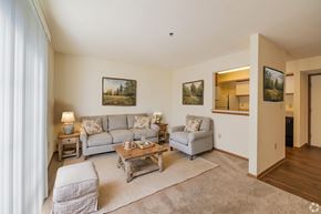 Lawrence apartment for rent - A living room with a grey couch, a chair, a coffee table, and pictures on the wall.