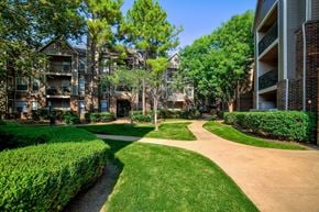 Tulsa apartment for rent - A pathway leads through a grassy area between two apartment buildings.