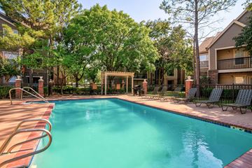 Tulsa apartment for rent - A swimming pool surrounded by trees and chairs.