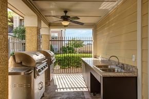 Tulsa apartment for rent - A patio with a sink and grill is covered by a roof.