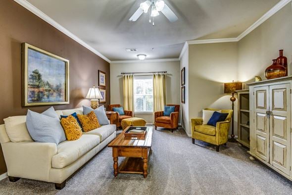 Tulsa apartment for rent - A living room with a white couch, a yellow chair, and a painting on the wall.
