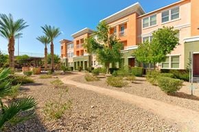 Henderson townhouse for rent - A sunny day at a residential area with apartment buildings and palm trees.