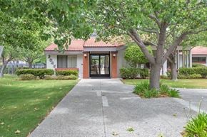 Encinitas apartment for rent - The image shows a building with a red roof and a tree in front of it.