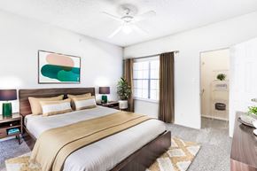 Plano apartment for rent - Large bedroom with brown bed and curtains at Saxony at Chase Oaks, Texas