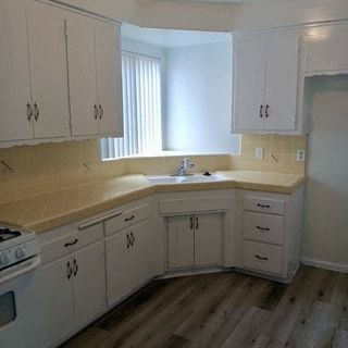 Valley Village apartment for rent - A kitchen with white cabinets and a wooden floor.