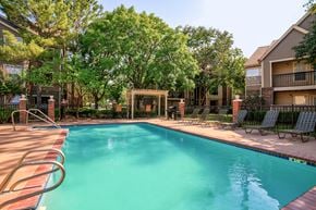 Tulsa apartment for rent - A swimming pool surrounded by trees and chairs.
