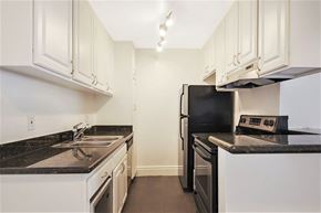 Los Angeles apartment for rent - a kitchen with white cabinets and black appliances