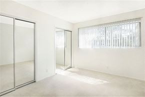 Los Angeles apartment for rent - an empty bedroom with mirrored closet doors and a window