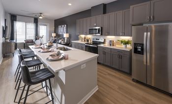 Sleek kitchen cabinetry with modern cabinet accents, pull out garbage drawer and soft-close hinges