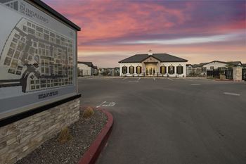 A sign for bungalow's sits in front of a building with a parking lot in the foreground.