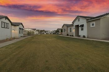 A row of houses with a grassy lawn in the foreground.