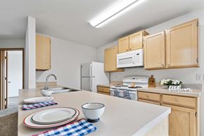 Coeur D’Alene apartment for rent - a kitchen with wooden cabinets and white appliances