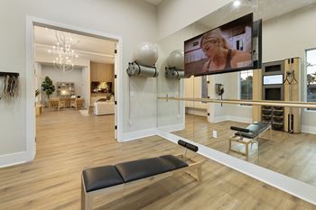 A room with a bench and a television mounted on the wall.