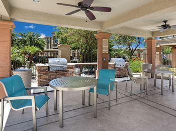 A patio with a table and chairs under a roof.