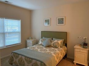 Fredericksburg apartment for rent - A bedroom with a bed, nightstand, and window.