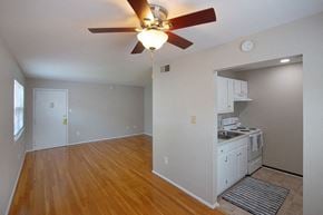 Hampton apartment for rent - A room with a ceiling fan and wooden floors.
