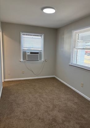 Newport News apartment for rent - A room with a carpeted floor and a window with blinds.