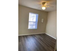 Newport News apartment for rent - an empty living room with a ceiling fan and a window