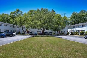 Newport News townhouse for rent - A sunny day at a residential area with a grassy lawn and apartment buildings.