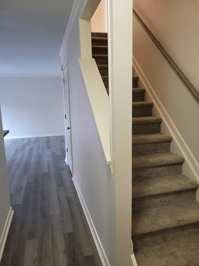 Morehead City apartment for rent - a view down the stairs in a home with wood floors and white walls