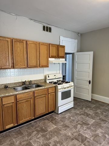 Newport News townhouse for rent - A kitchen with wooden cabinets and a white stove top oven.