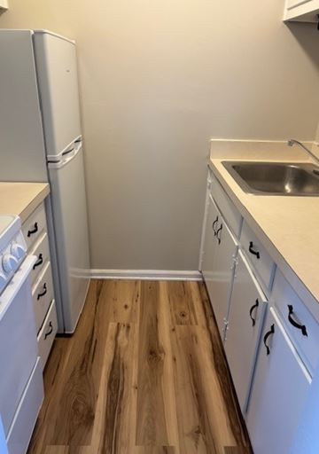 Newport News apartment for rent - A kitchen with white cabinets and a white fridge.