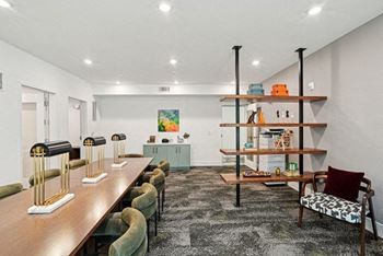 A living room with a long wooden table and chairs