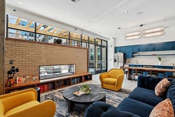 A living room with a yellow chair and a black couch.