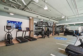 A gym with treadmills, weights, and exercise equipment.