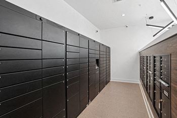A long hallway with a row of black mailboxes on the wall.