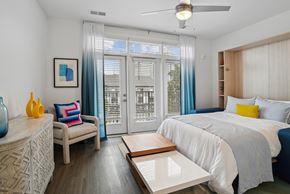 Charlotte apartment for rent - a bedroom with a bed and a sliding glass door at Link Apartments® Mint Street, Charlotte, North Carolina