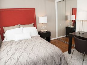 Chapel Hill apartment for rent - A bedroom with a large bed and a red headboard.