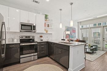 A kitchen with a sink and a stove and a microwave