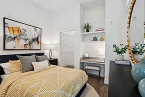 Charlotte apartment for rent - A bedroom with a bed, a desk, and a mirror. at Link Apartments® NoDa 36th Apartments, Charlotte