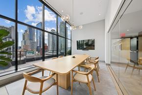 Long Island City apartment for rent - A conference room with a long table and chairs with a view of the city outside the window at Link Apartments® QPN, Long Island City, New York