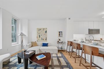 Long Island City apartment for rent - A modern living room with a white couch and a coffee table.