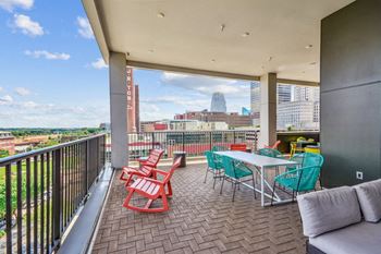A balcony with a table and chairs and a view of the city