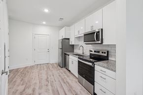 Charlotte apartment for rent - A kitchen with white cabinets and a black stove top oven at Link Apartments® CYKEL Apartments, Charlotte, NC