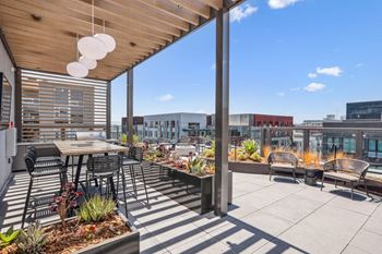 A patio with tables and chairs on the roof of a building