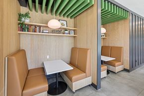 Charlotte apartment for rent - A modern dining area with tan leather chairs and a wooden table at Link Apartments® CYKEL Apartments, Charlotte, North Carolina